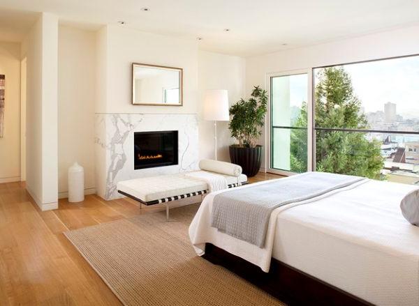 Fireplace in marble in a spacious and bright bedroom