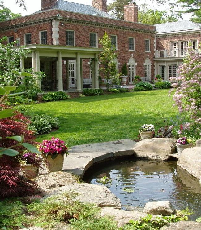 A neat body of water surrounded by stones and flowerpots