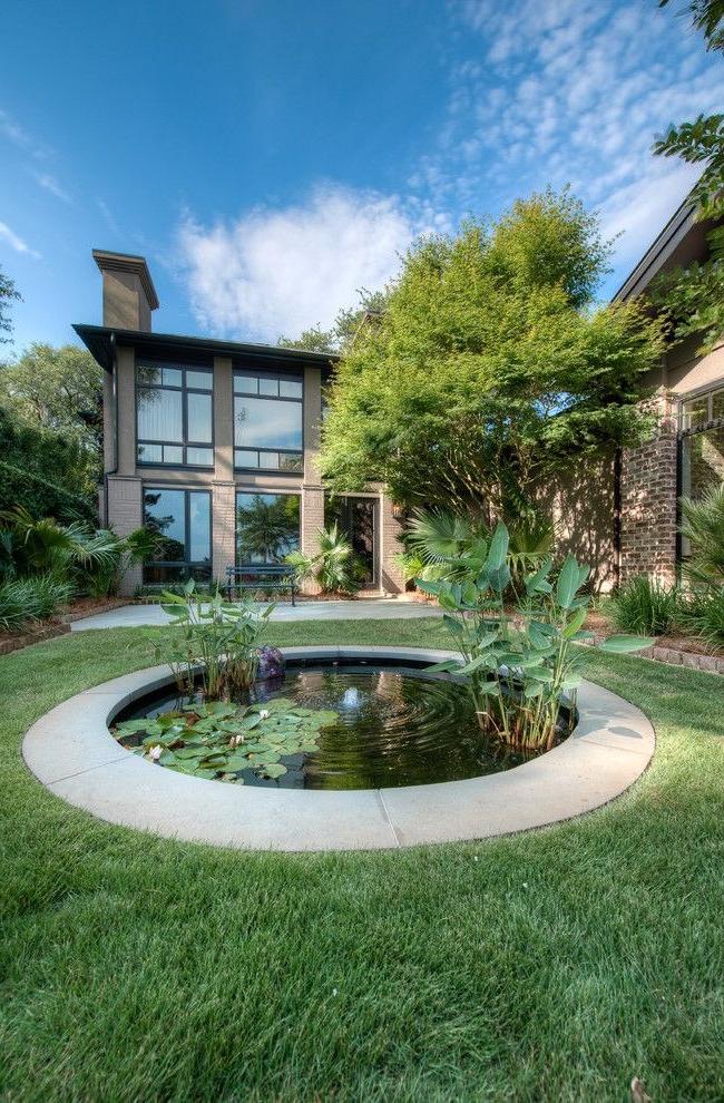 Round pond with a small fountain in the middle of the lawn