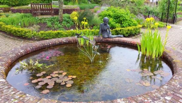 Sculpture of a girl by the garden pond